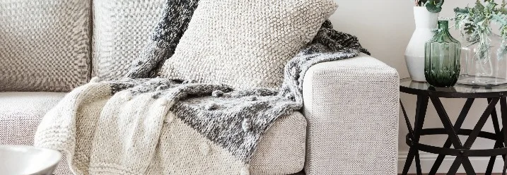 Gemütliches Wohnzimmer mit Sofa und Decken